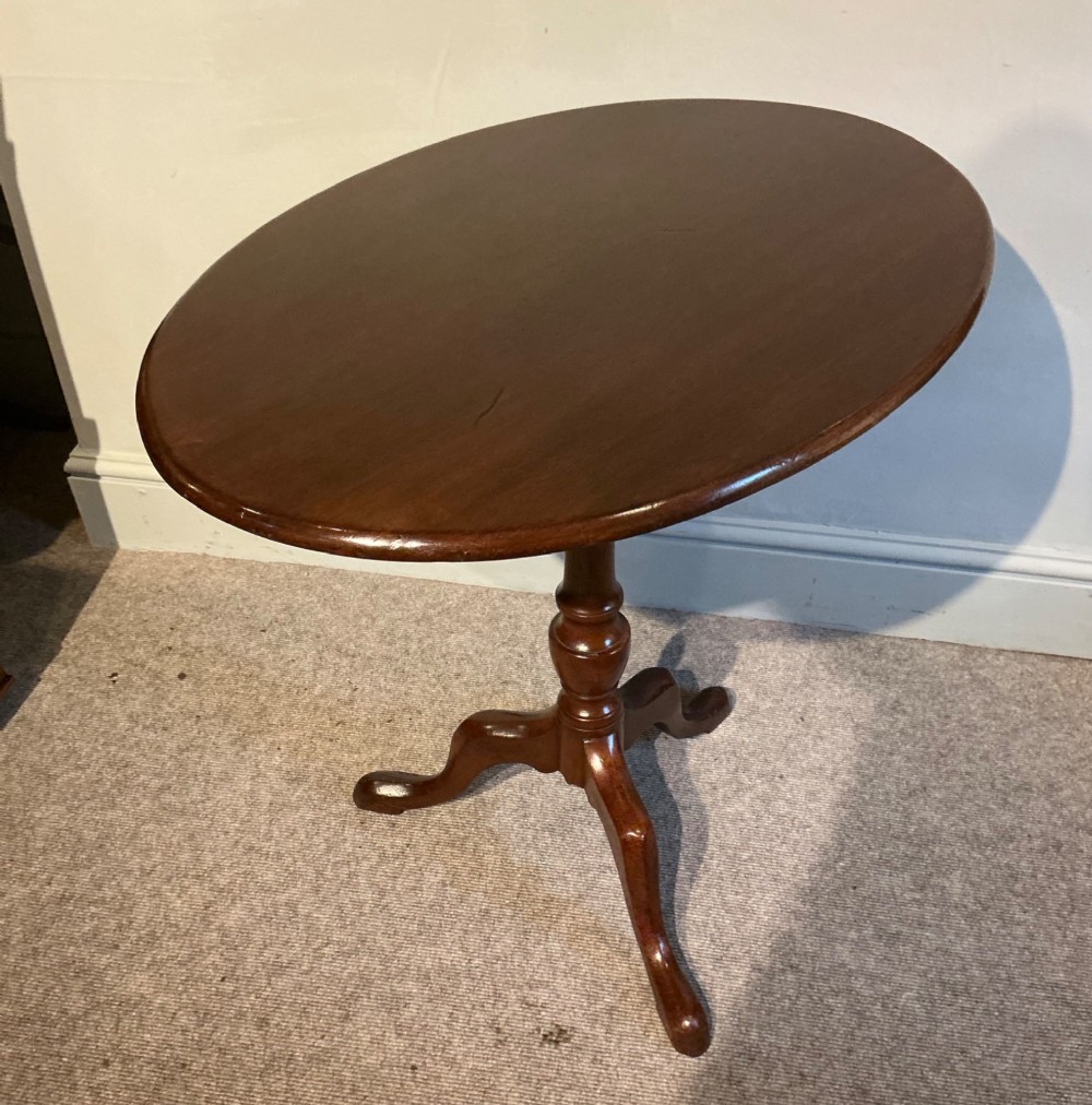 A circular mahogany tripod table featuring a turned central pedestal supported by three cabriole legs ending in pad feet. View III