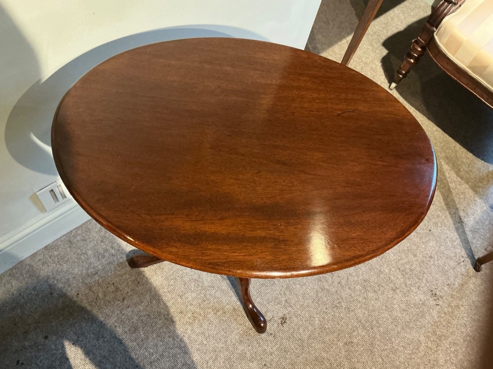 A circular mahogany tripod table featuring a turned central pedestal supported by three cabriole legs ending in pad feet. View IV