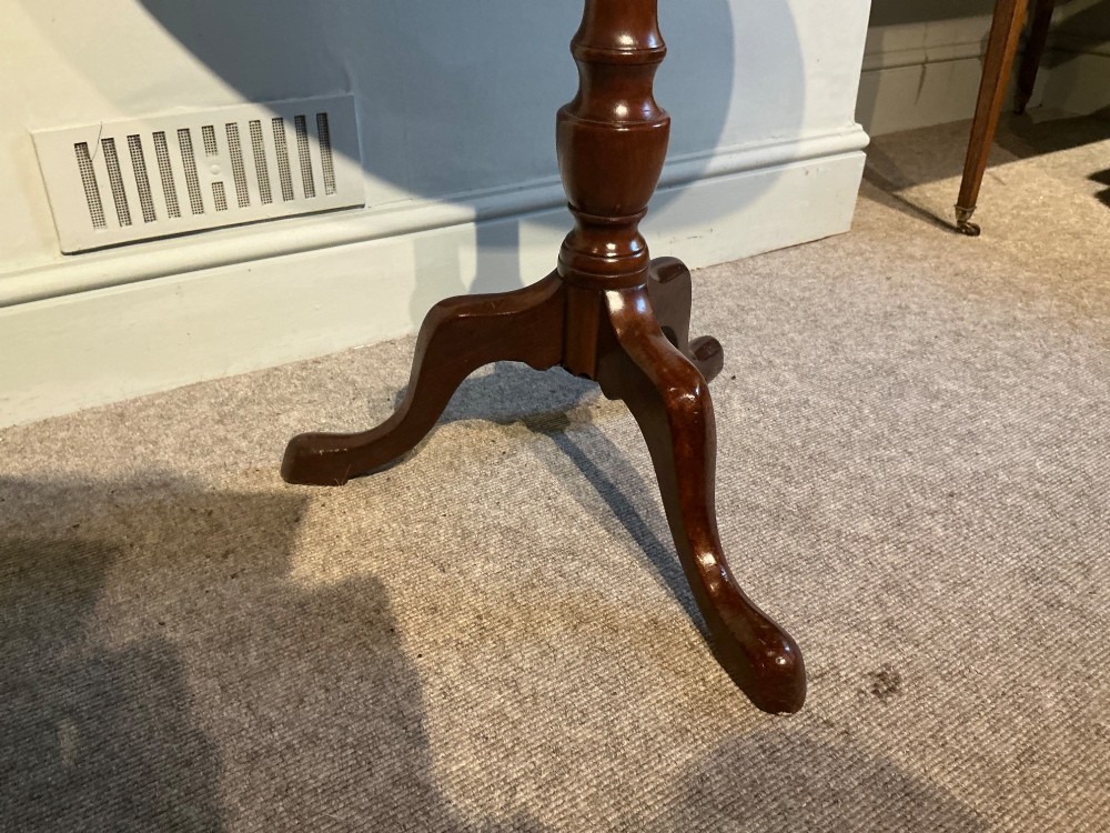 A circular mahogany tripod table featuring a turned central pedestal supported by three cabriole legs ending in pad feet. View VI