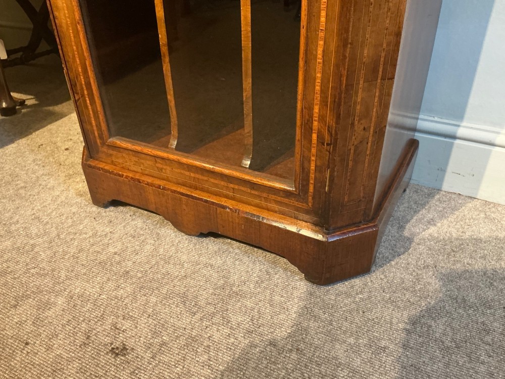 A Victorian burr walnut music cabinet featuring inlaid boxwood stringing, a top drawer, a glazed door revealing internal shelves and vertical dividers, and a brass gallery rail. View III