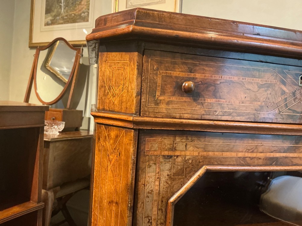 A Victorian burr walnut music cabinet featuring inlaid boxwood stringing, a top drawer, a glazed door revealing internal shelves and vertical dividers, and a brass gallery rail. View X