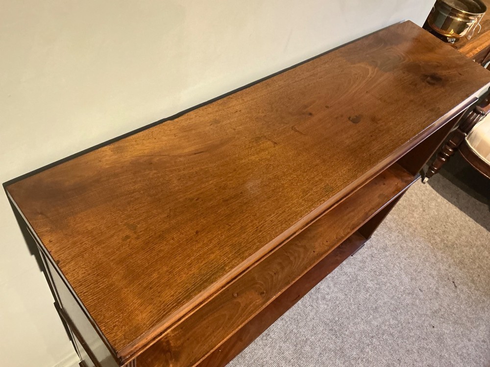 A low open mahogany bookcase featuring two wide shelves, reeded side pilasters, a panelled back, and low turned feet. View IV