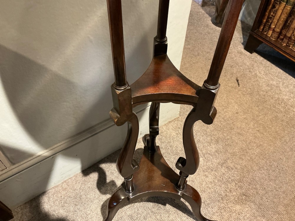 A dark mahogany torchere featuring a circular dished top supported by slender uprights, scroll details, and a tripod base with pad feet. View IV