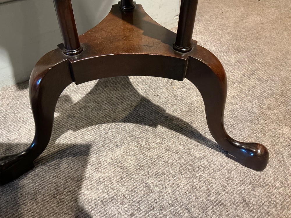 A dark mahogany torchere featuring a circular dished top supported by slender uprights, scroll details, and a tripod base with pad feet. View VII