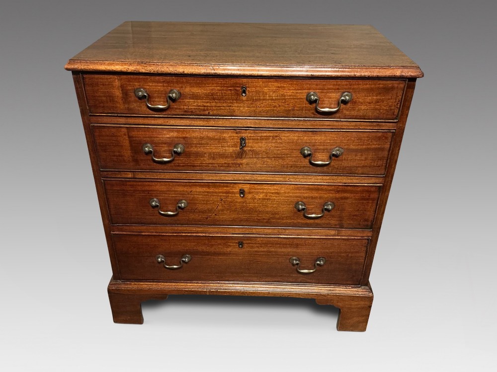 A Georgian mahogany chest of drawers featuring four graduated drawers with brass swan-neck handles and bracket feet.