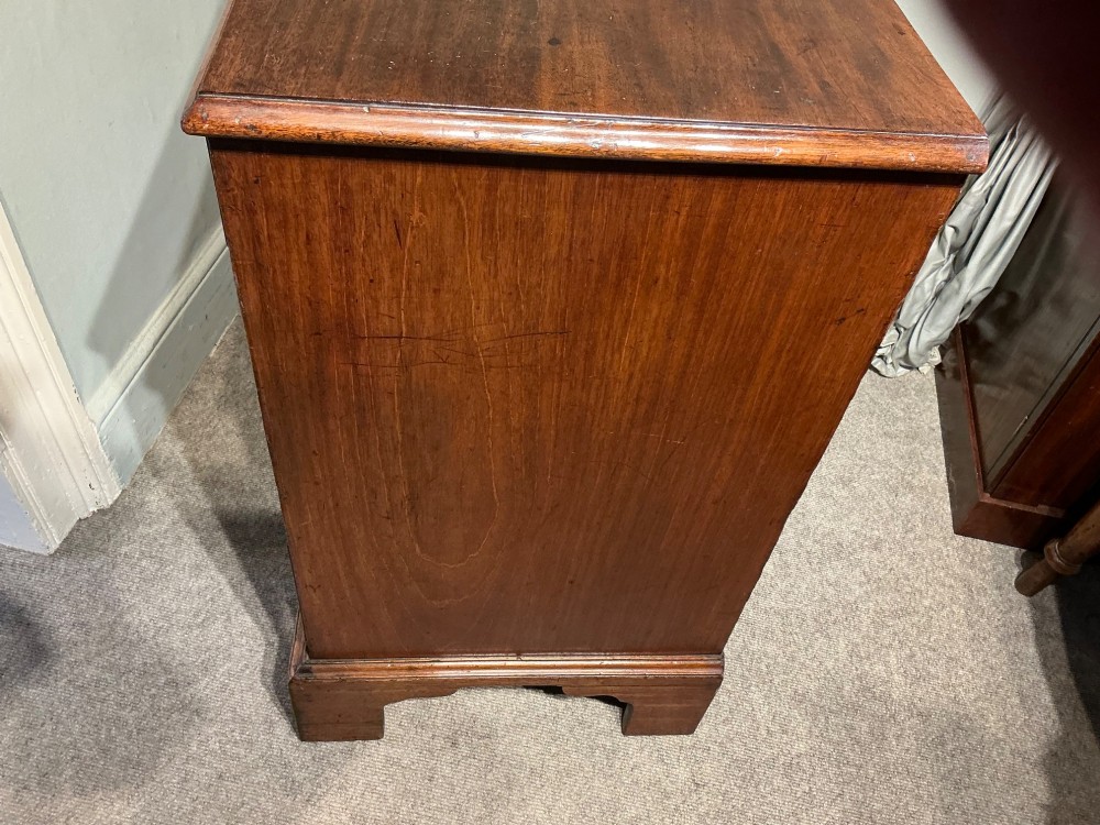 A Georgian mahogany chest of drawers featuring four graduated drawers with brass swan-neck handles and bracket feet. View VIII