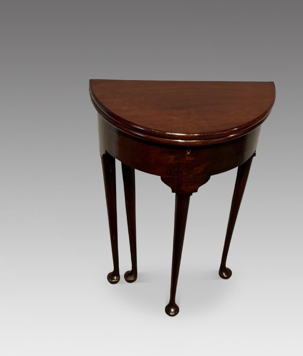 A dark mahogany demi-lune fold-over tea table with slender tapered legs, pad feet, and a brass keyhole escutcheon on the apron. View II