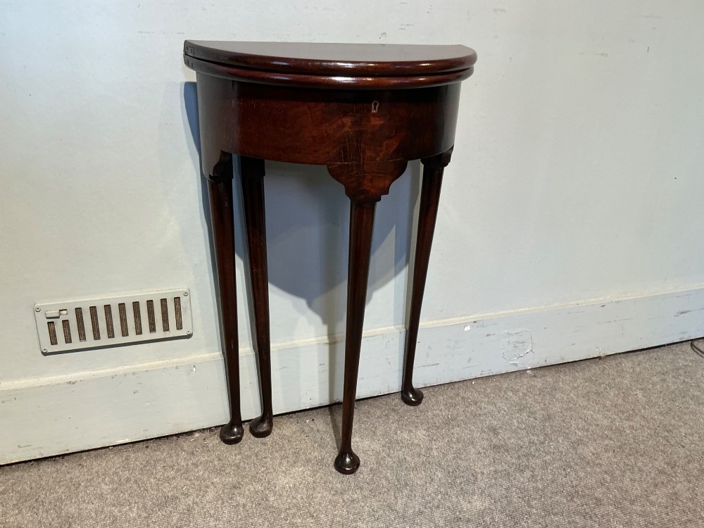 A dark mahogany demi-lune fold-over tea table with slender tapered legs, pad feet, and a brass keyhole escutcheon on the apron. View III