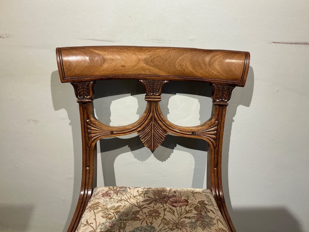 A set of four antique mahogany dining chairs with carved palmette back splats, curved crest rails, sabre legs, and floral tapestry upholstered drop-in seats. View III