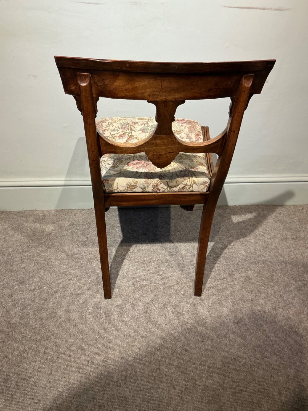 A set of four antique mahogany dining chairs with carved palmette back splats, curved crest rails, sabre legs, and floral tapestry upholstered drop-in seats. View VII