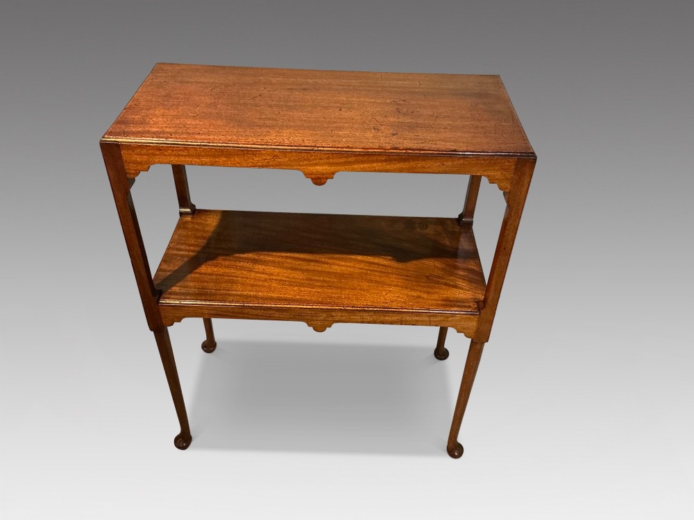 A rectangular mahogany two-tier occasional table with slender legs, pad feet, and shaped aprons. View II