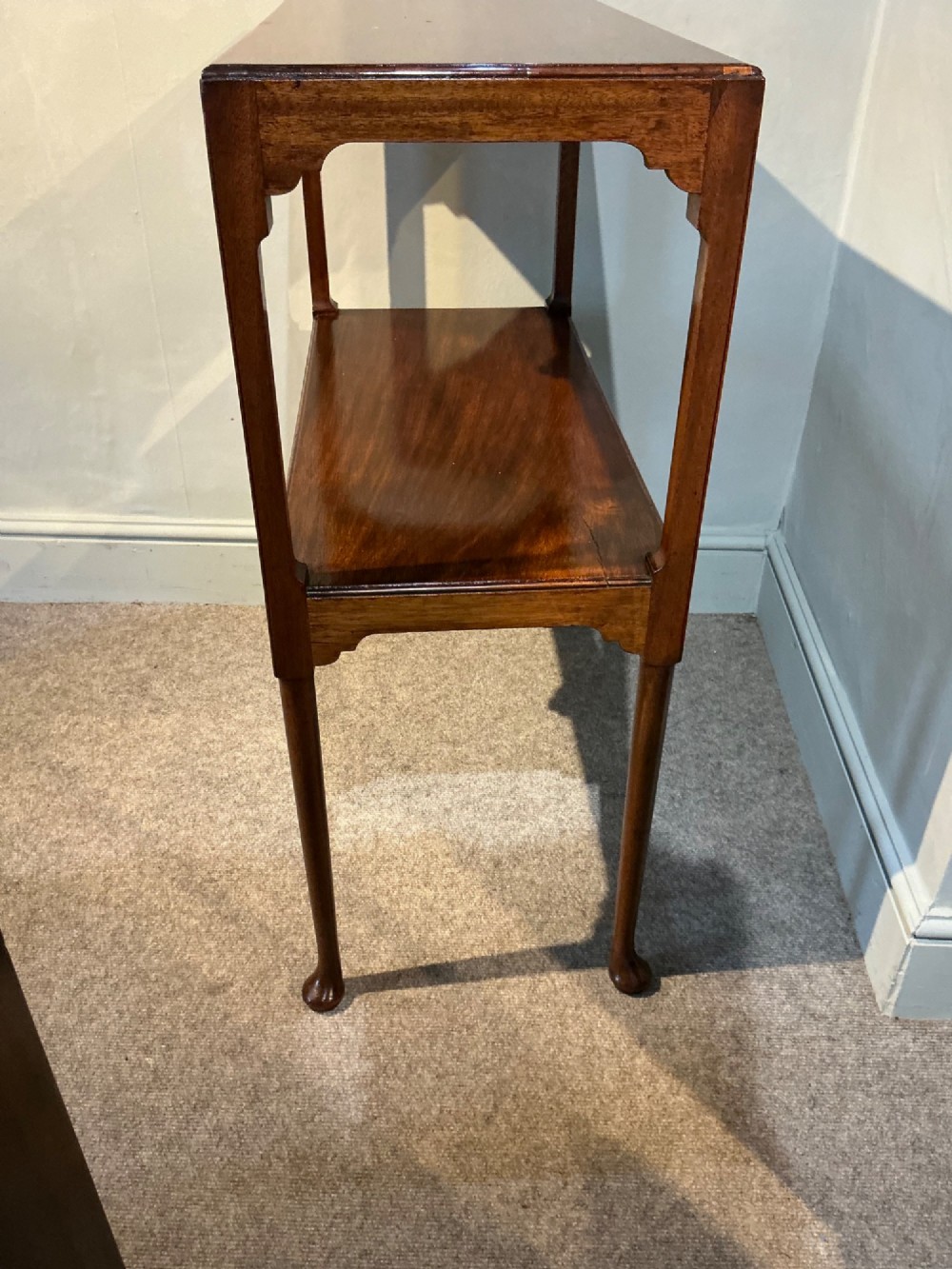 A rectangular mahogany two-tier occasional table with slender legs, pad feet, and shaped aprons. View VI