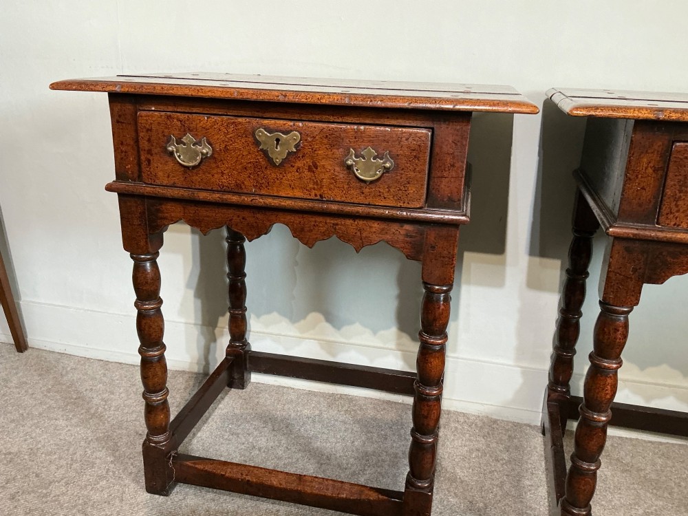 A matching pair of dark brown oak side tables featuring single frieze drawers with brass handles, turned legs, and square perimeter stretchers. View III