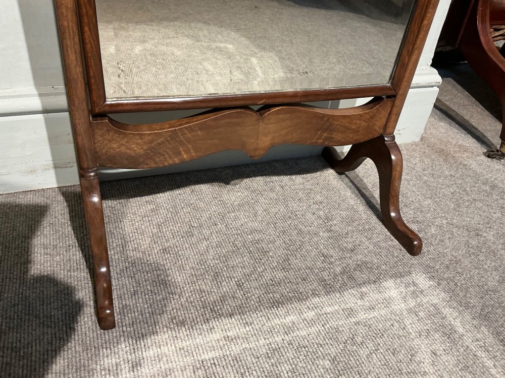 An antique arched walnut table mirror resting on vertical upright supports with turned finials and scrolled feet. View III