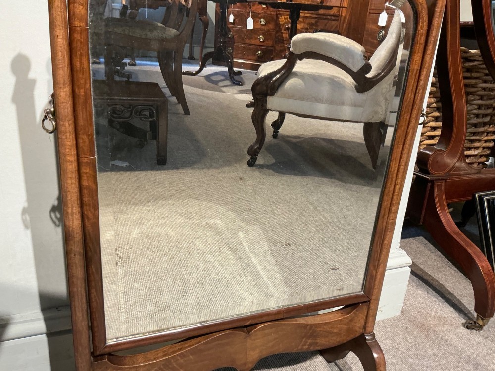 An antique arched walnut table mirror resting on vertical upright supports with turned finials and scrolled feet. View IV