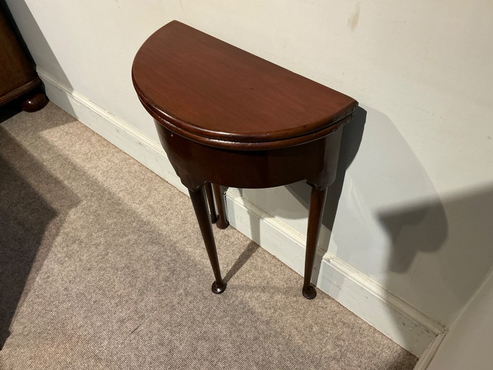 A dark mahogany demi-lune console table featuring a fold-over top, straight apron, and slender tapered legs ending in pad feet. View II