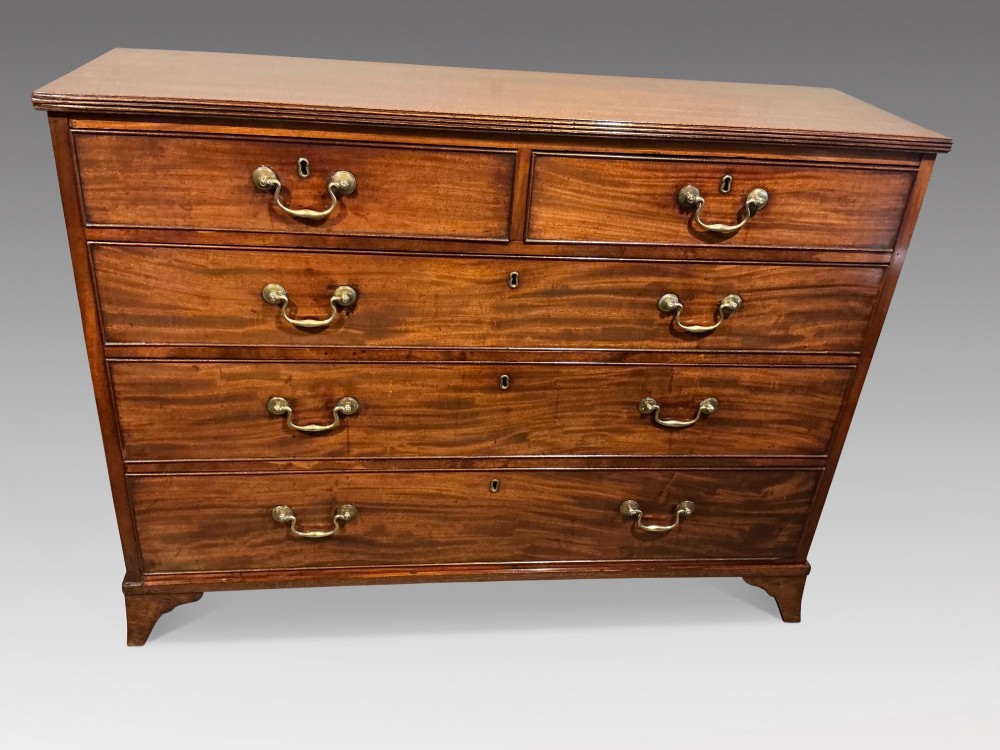 A Georgian mahogany chest of drawers featuring two short over three long graduated drawers with brass swan-neck handles and bracket feet.