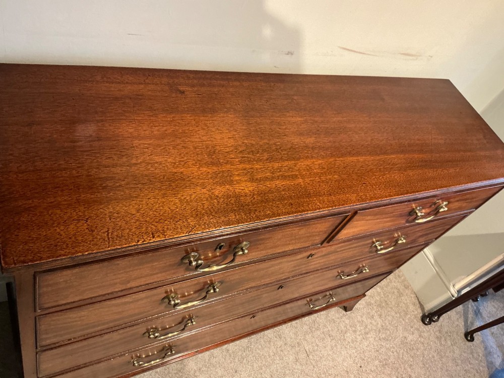 A Georgian mahogany chest of drawers featuring two short over three long graduated drawers with brass swan-neck handles and bracket feet. View III