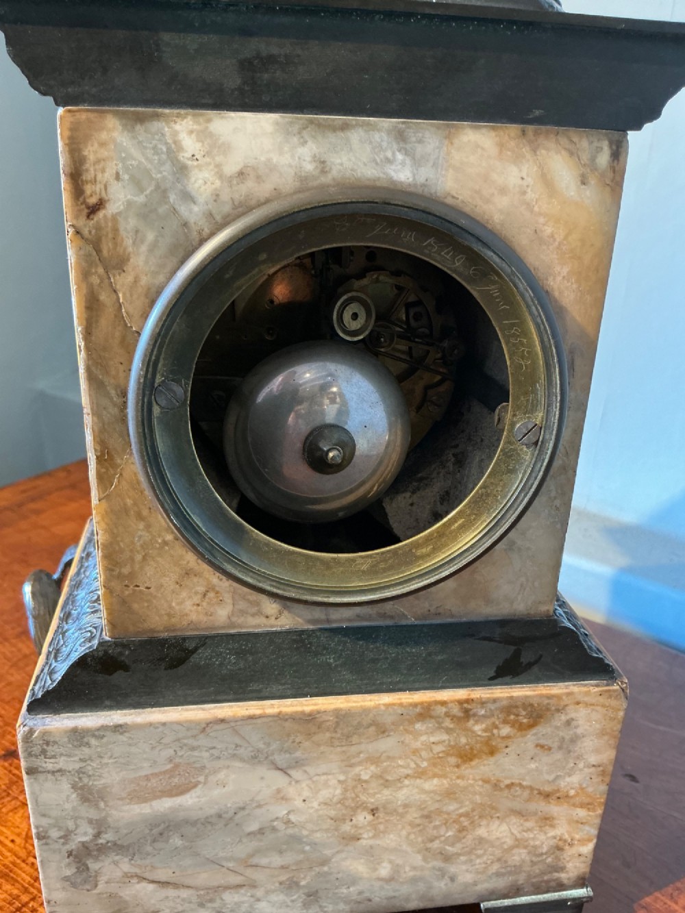 A French Empire style mantel clock featuring a dark patinated bronze figure of Napoleon standing above a yellow marble plinth housing a circular metal dial. View VI