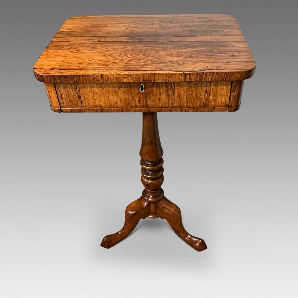An antique rosewood pedestal table featuring a rectangular top with rounded corners, a keyhole in the frieze, a turned central stem, and a tripod base.