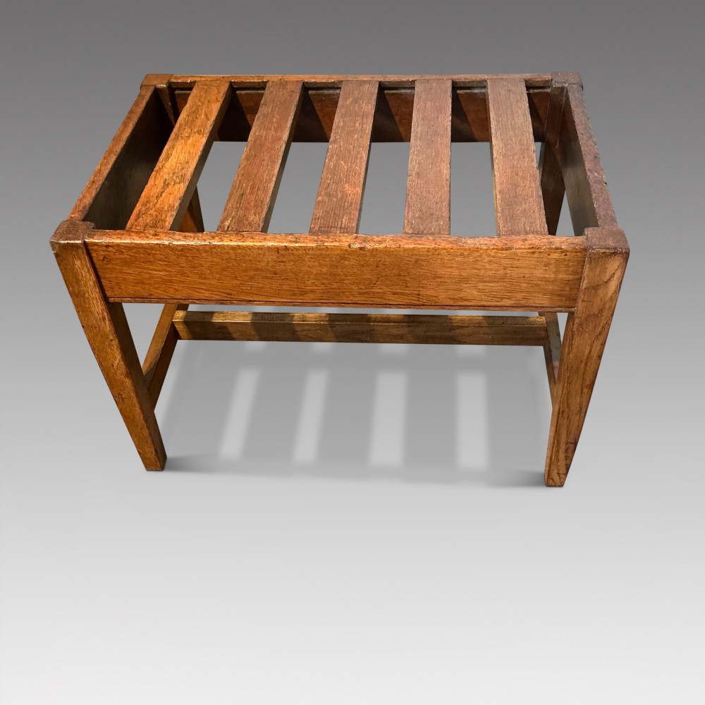 A solid oak antique luggage rack featuring five rectangular top slats supported by square legs and cross stretchers. View II