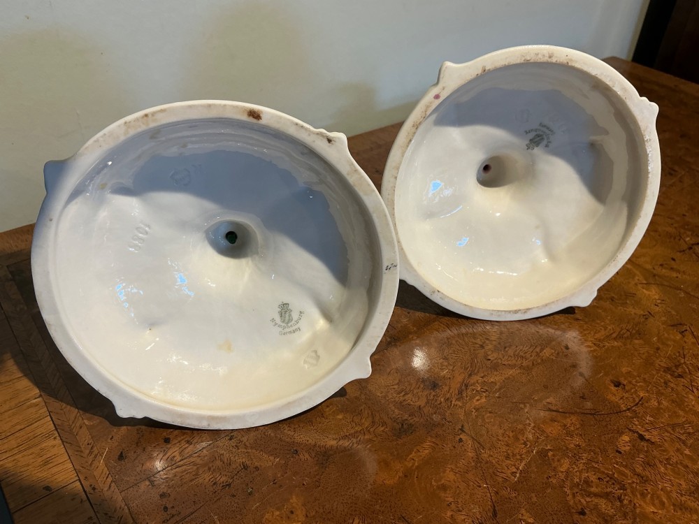 A pair of off-white glazed porcelain candlesticks featuring sculpted Rococo scrollwork and shell motifs on wide circular bases. View VIII