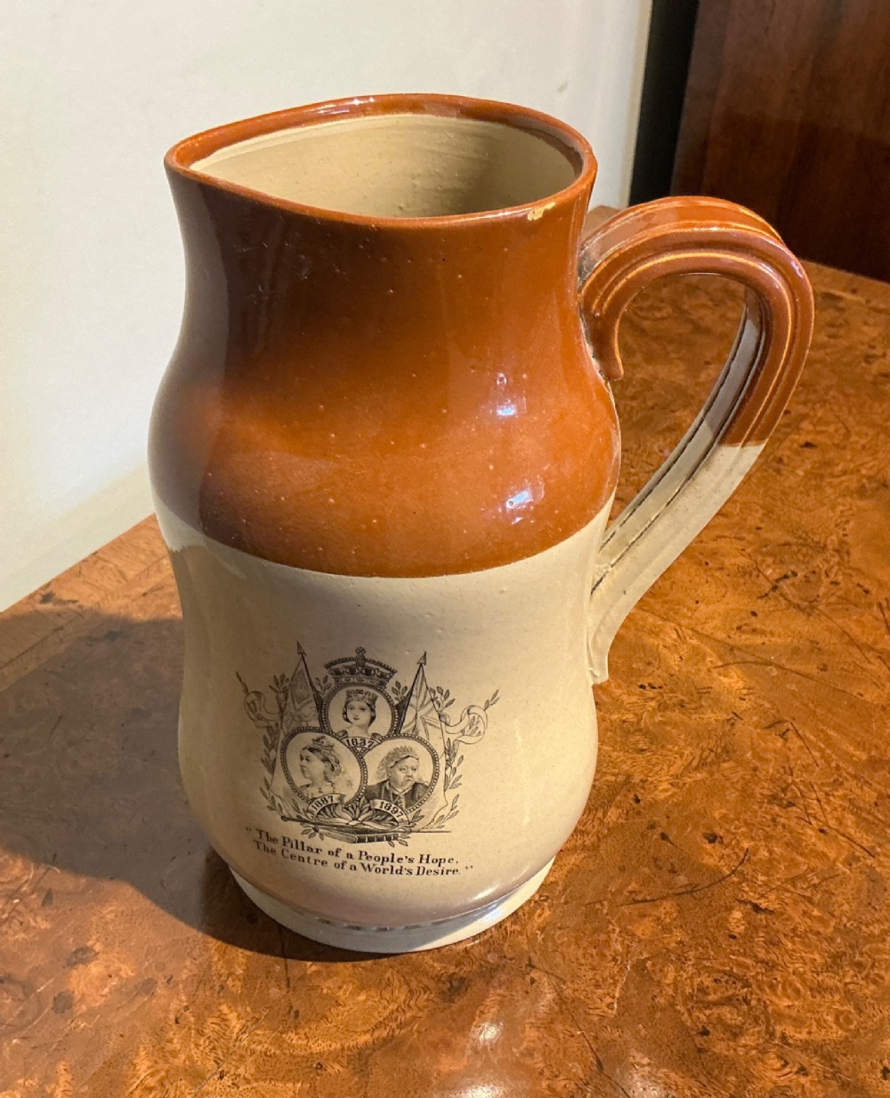 A late nineteenth-century two-tone stoneware jug featuring a rich brown glazed neck, a cream body, and a black transfer-printed portrait commemorating Queen Victoria. View III