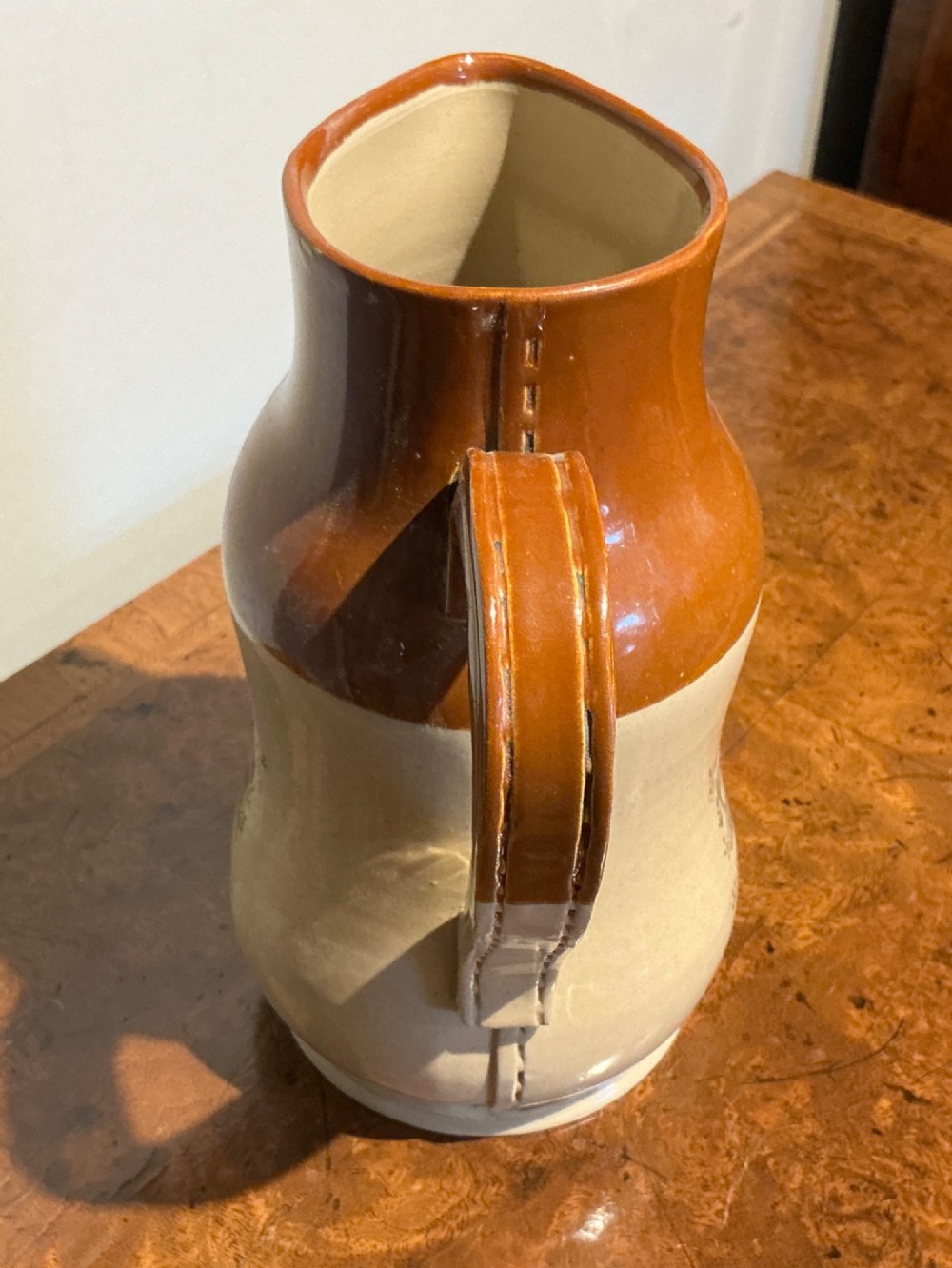 A late nineteenth-century two-tone stoneware jug featuring a rich brown glazed neck, a cream body, and a black transfer-printed portrait commemorating Queen Victoria. View IV