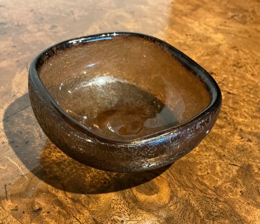 A small rounded square smoky brown blown glass bowl with an acid-etched corroso textured exterior and smooth polished interior. View II