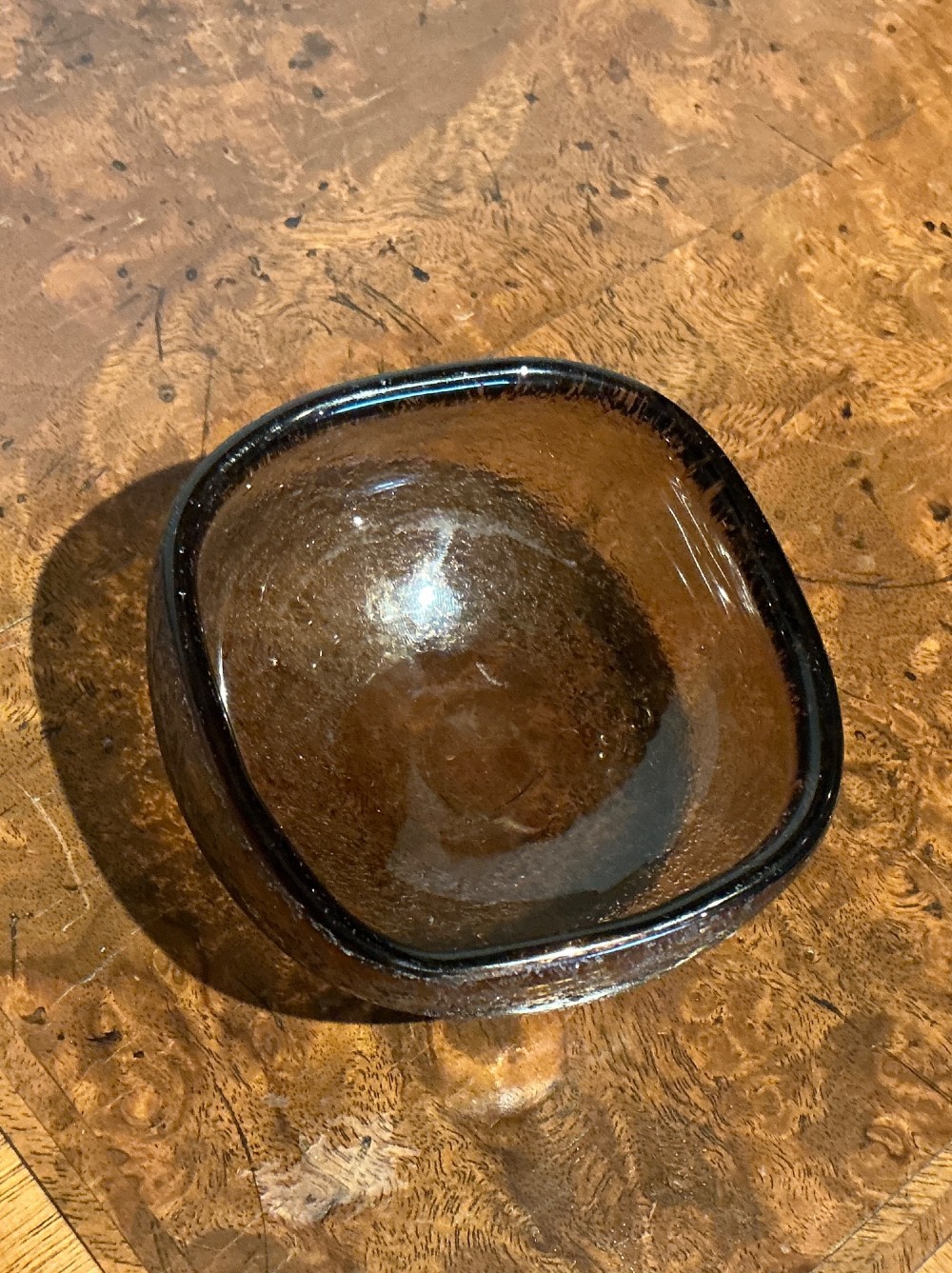 A small rounded square smoky brown blown glass bowl with an acid-etched corroso textured exterior and smooth polished interior. View III