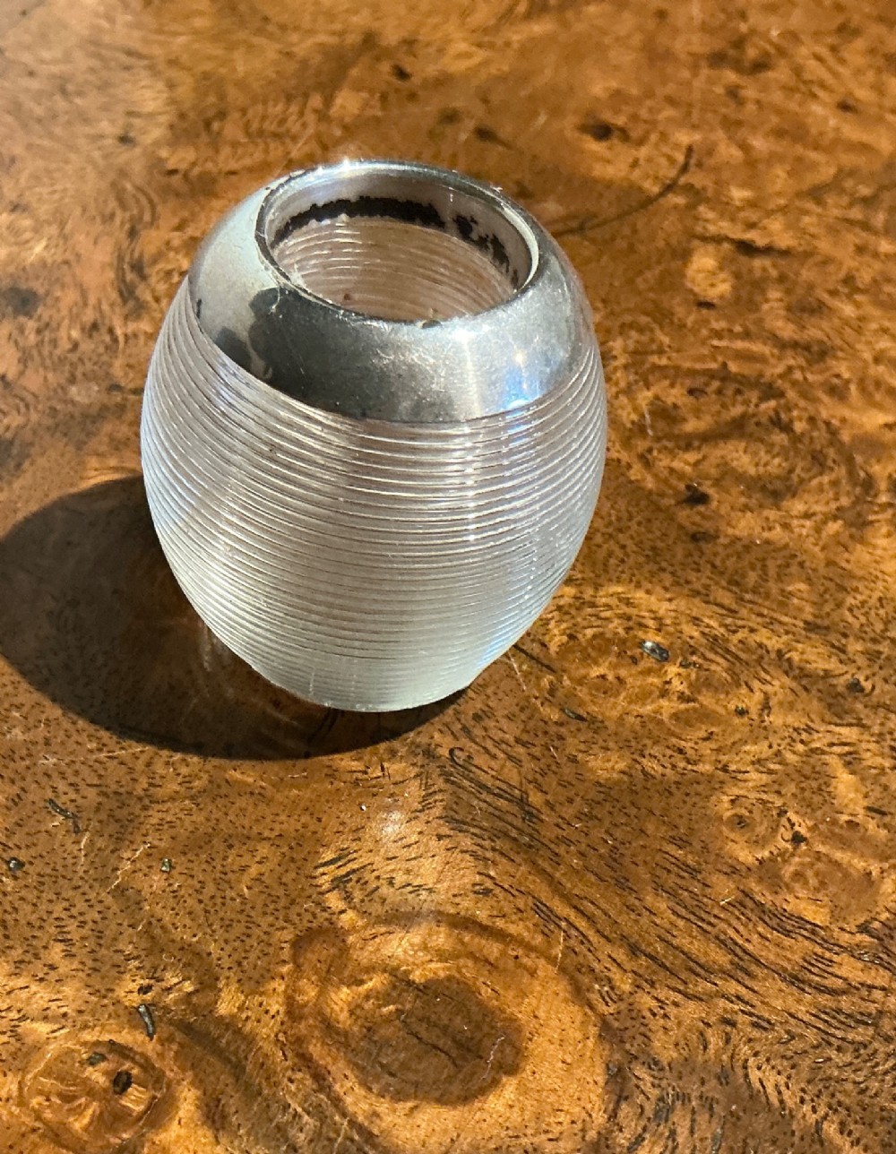 A globular glass match striker featuring a ribbed clear glass body and a hallmarked sterling silver collar around the top opening. View II
