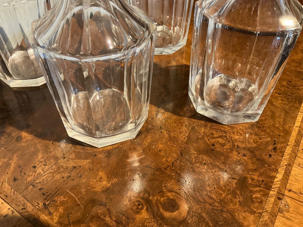 A set of four matching clear cut crystal liqueur decanters featuring panelled bodies and facet-cut stoppers. View III