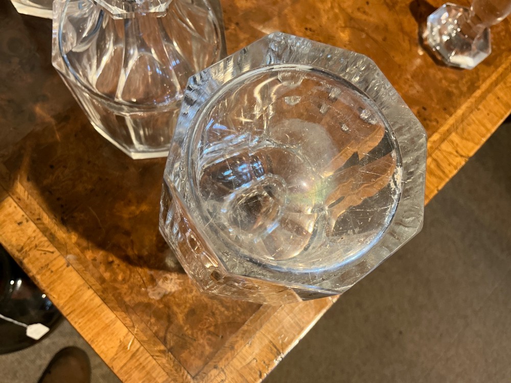 A set of four matching clear cut crystal liqueur decanters featuring panelled bodies and facet-cut stoppers. View V