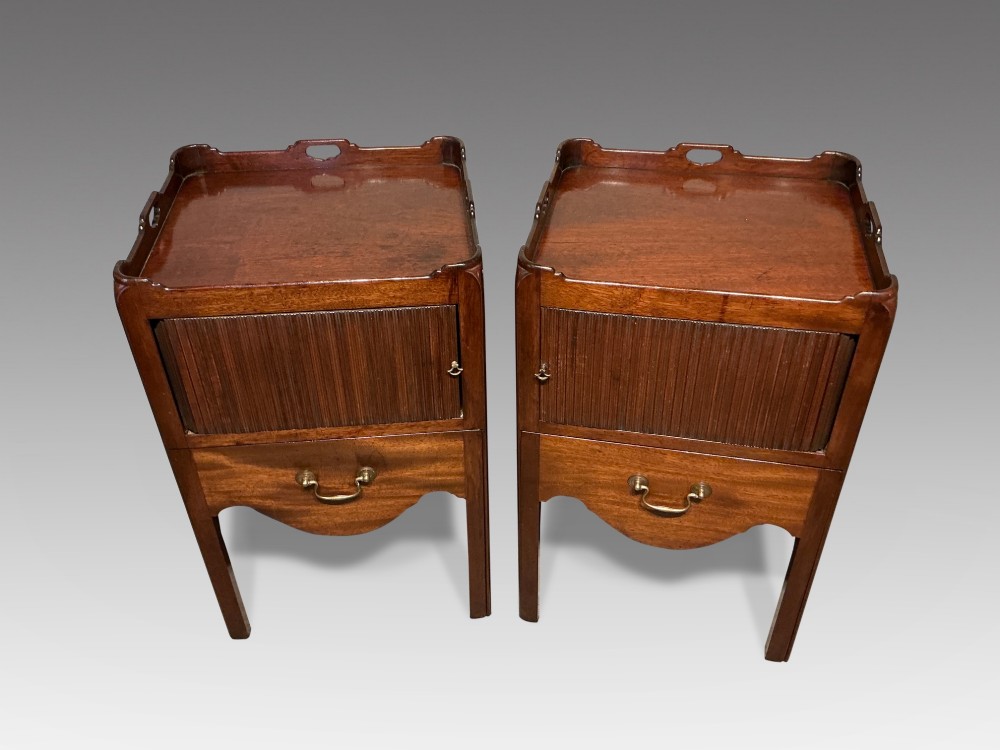 A pair of mahogany bedside cabinets featuring tray tops with gallery handles, slatted tambour cupboard doors, single drawers with brass handles, and square straight legs. View II