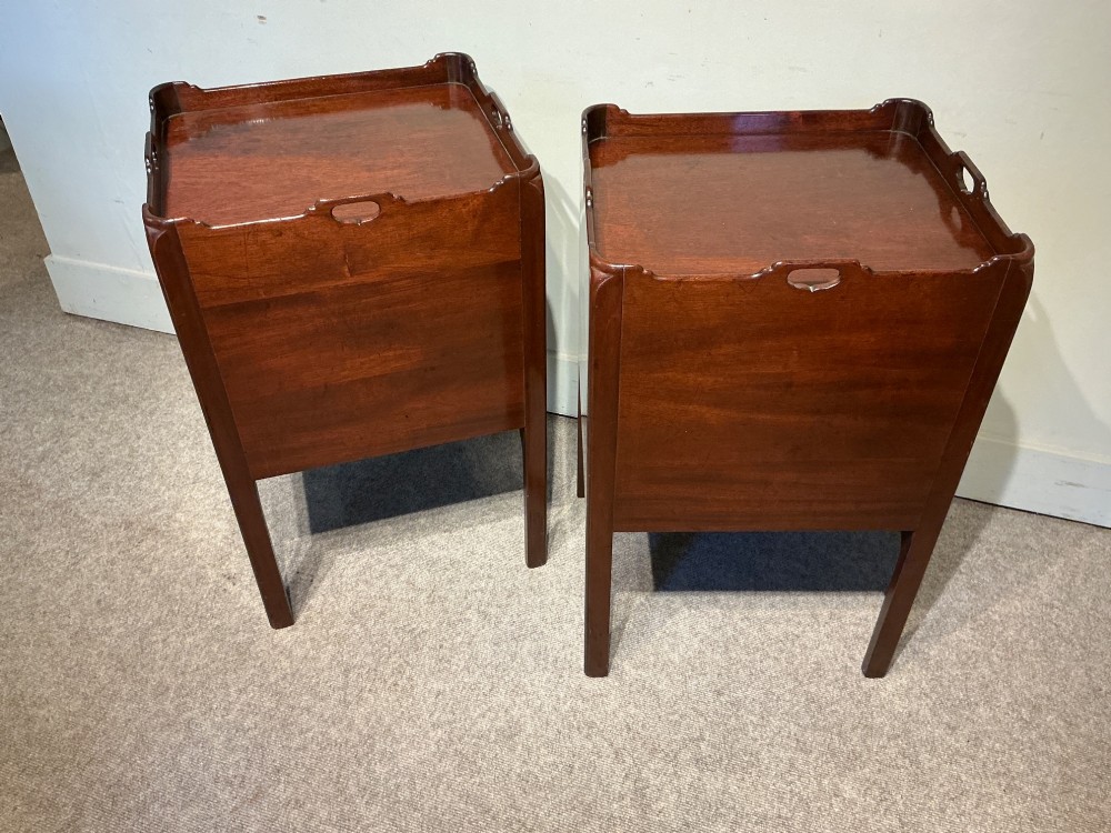 A pair of mahogany bedside cabinets featuring tray tops with gallery handles, slatted tambour cupboard doors, single drawers with brass handles, and square straight legs. View VI