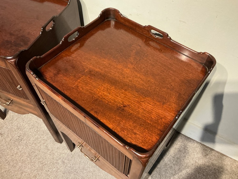A pair of mahogany bedside cabinets featuring tray tops with gallery handles, slatted tambour cupboard doors, single drawers with brass handles, and square straight legs. View VII