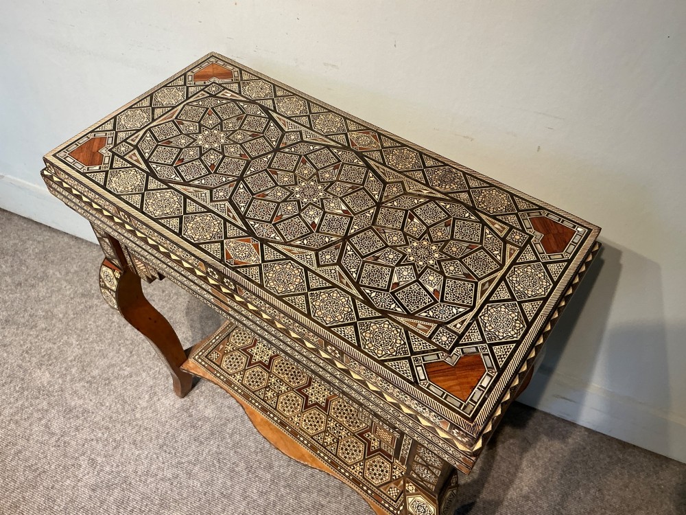 An antique Syrian Damascus games table featuring intricate geometric mother-of-pearl and wood inlay with cabriole legs and a matching lower shelf. View III