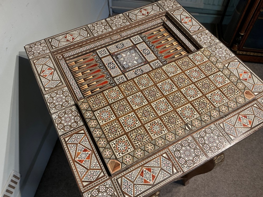 An antique Syrian Damascus games table featuring intricate geometric mother-of-pearl and wood inlay with cabriole legs and a matching lower shelf. View IX