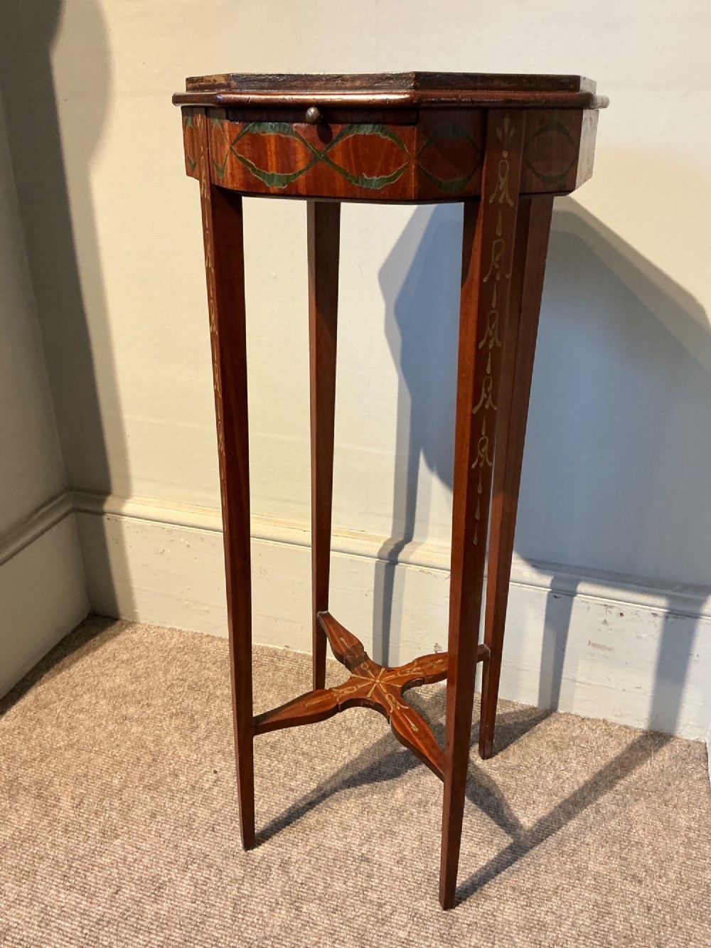 An octagonal antique satinwood urn stand featuring hand-painted floral garlands, a pull-out slide, slender tapered legs, and an X-shaped cross stretcher. View II