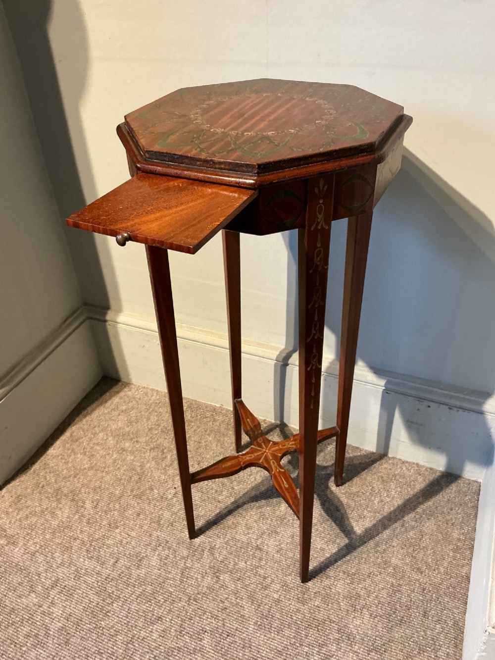 An octagonal antique satinwood urn stand featuring hand-painted floral garlands, a pull-out slide, slender tapered legs, and an X-shaped cross stretcher. View III