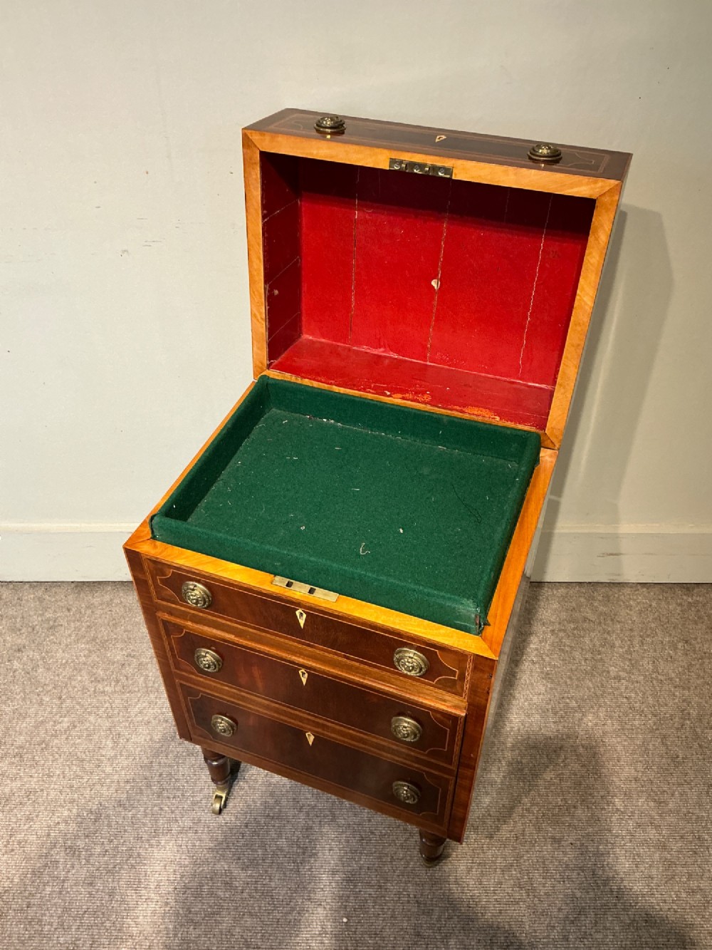 A nineteenth-century mahogany work table featuring satinwood inlay, bone escutcheons, brass ring handles, four drawer fronts, and turned legs on brass castors. View III
