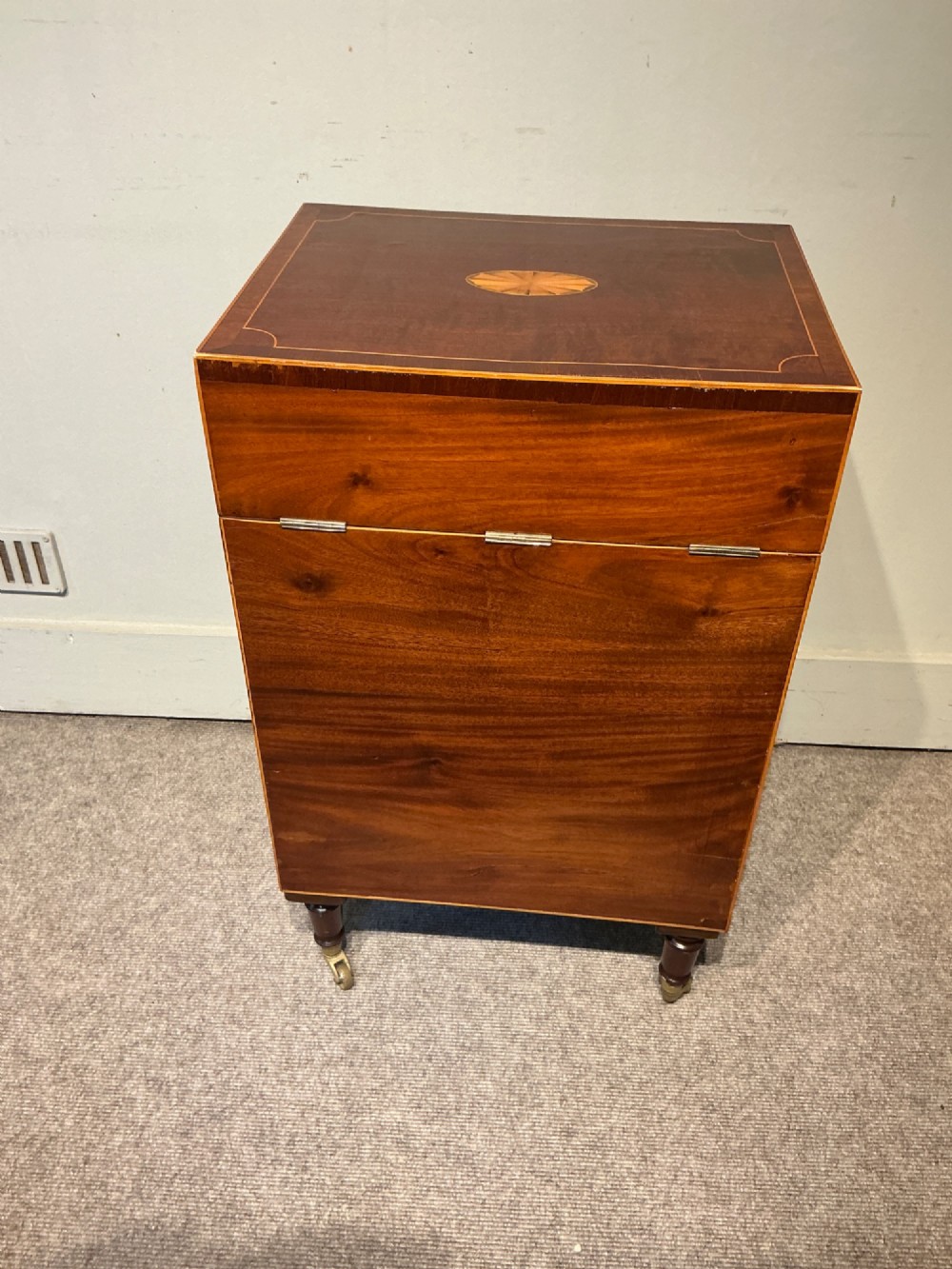 A nineteenth-century mahogany work table featuring satinwood inlay, bone escutcheons, brass ring handles, four drawer fronts, and turned legs on brass castors. View IX