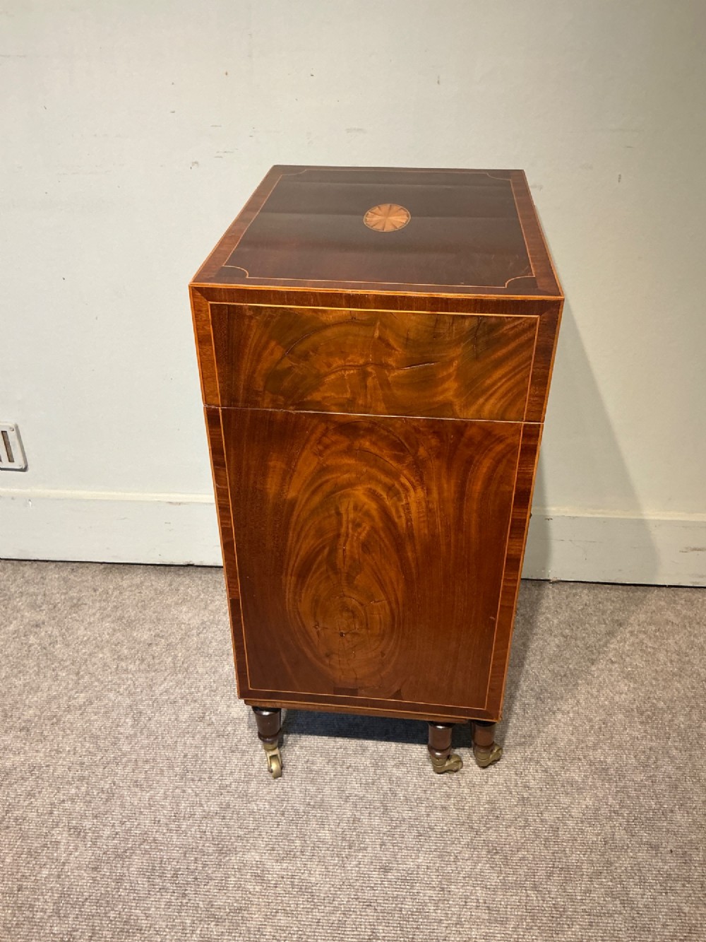 A nineteenth-century mahogany work table featuring satinwood inlay, bone escutcheons, brass ring handles, four drawer fronts, and turned legs on brass castors. View X