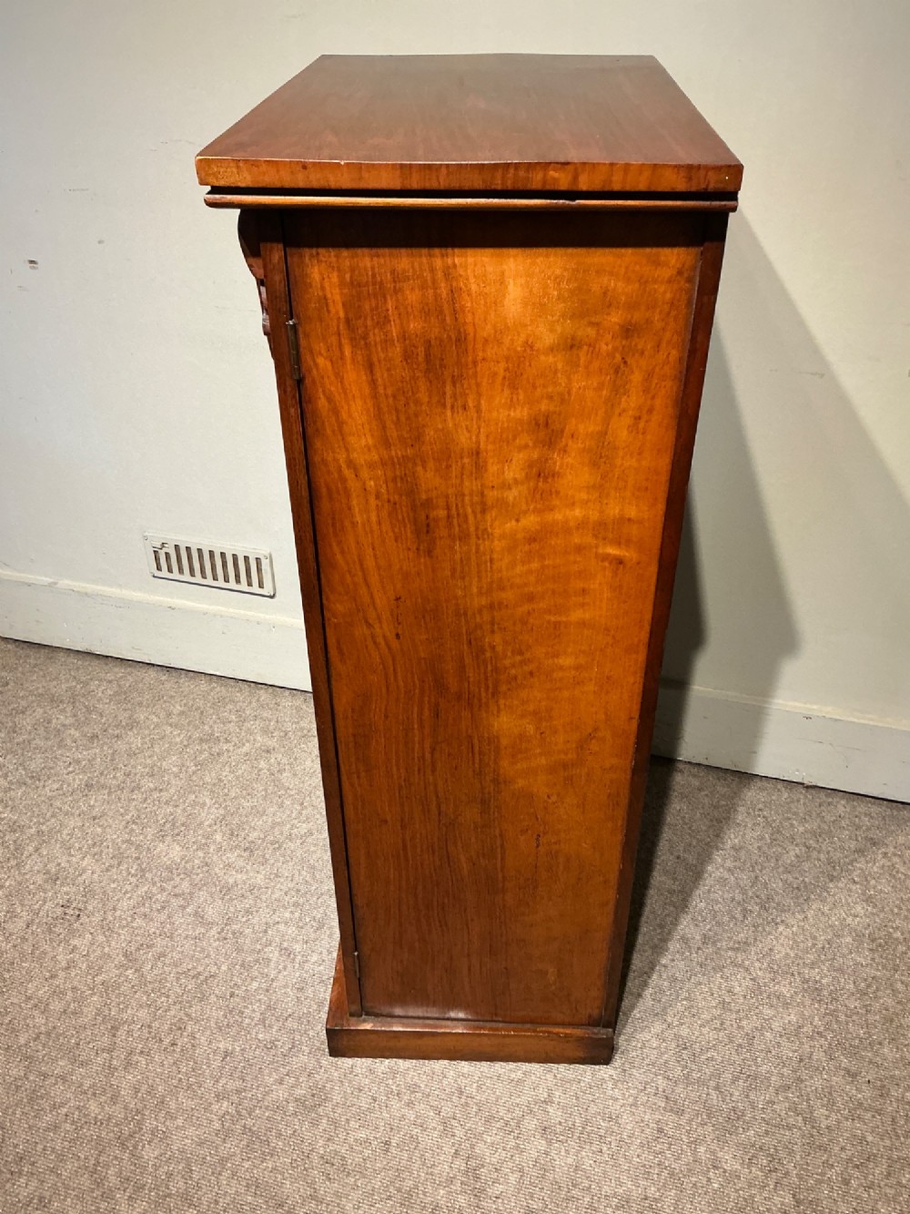 A tall, narrow Victorian walnut Wellington chest featuring seven stacked drawers with turned knobs, carved brackets, and a hinged locking pilaster. View IX