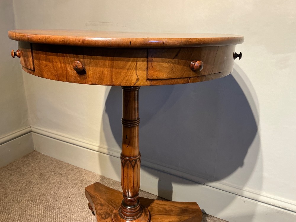 A circular antique Maltese olive wood drum table featuring a starburst veneered top with a central inlaid Maltese cross, supported on a turned central pedestal and a triform plinth base with bun feet. View V
