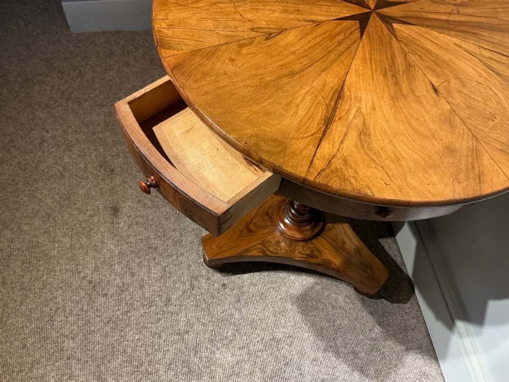 A circular antique Maltese olive wood drum table featuring a starburst veneered top with a central inlaid Maltese cross, supported on a turned central pedestal and a triform plinth base with bun feet. View VIII
