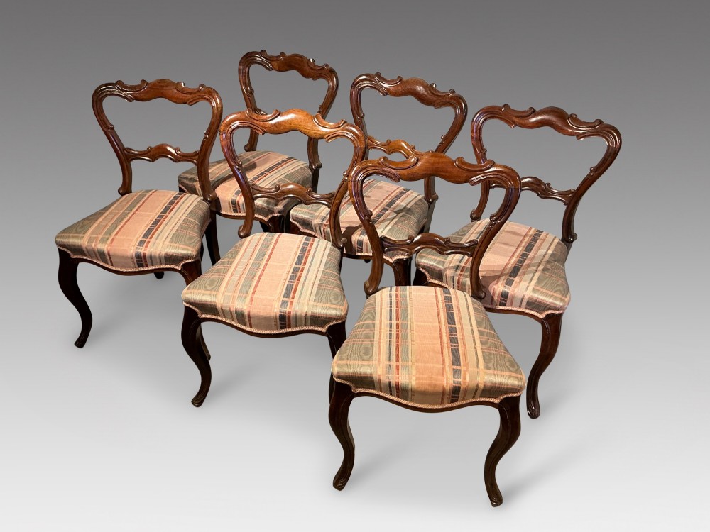 A set of six early Victorian balloon back dining chairs crafted from dark polished wood with striped upholstery. View II