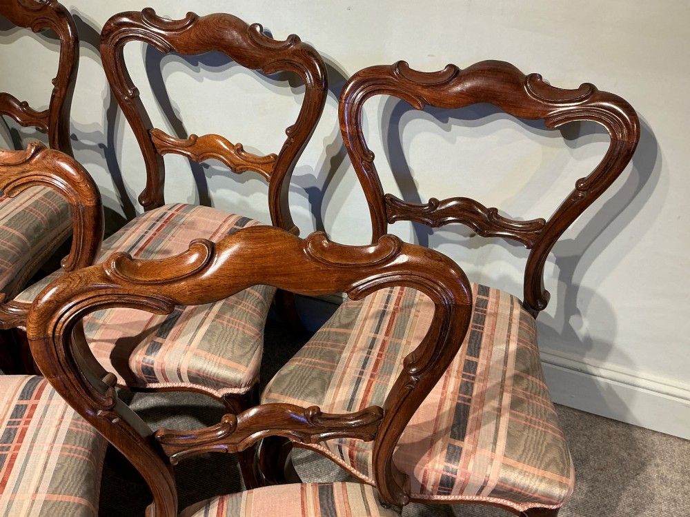 A set of six early Victorian balloon back dining chairs crafted from dark polished wood with striped upholstery. View III