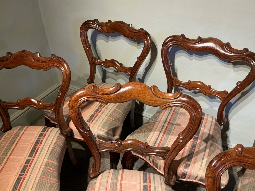 A set of six early Victorian balloon back dining chairs crafted from dark polished wood with striped upholstery. View IV