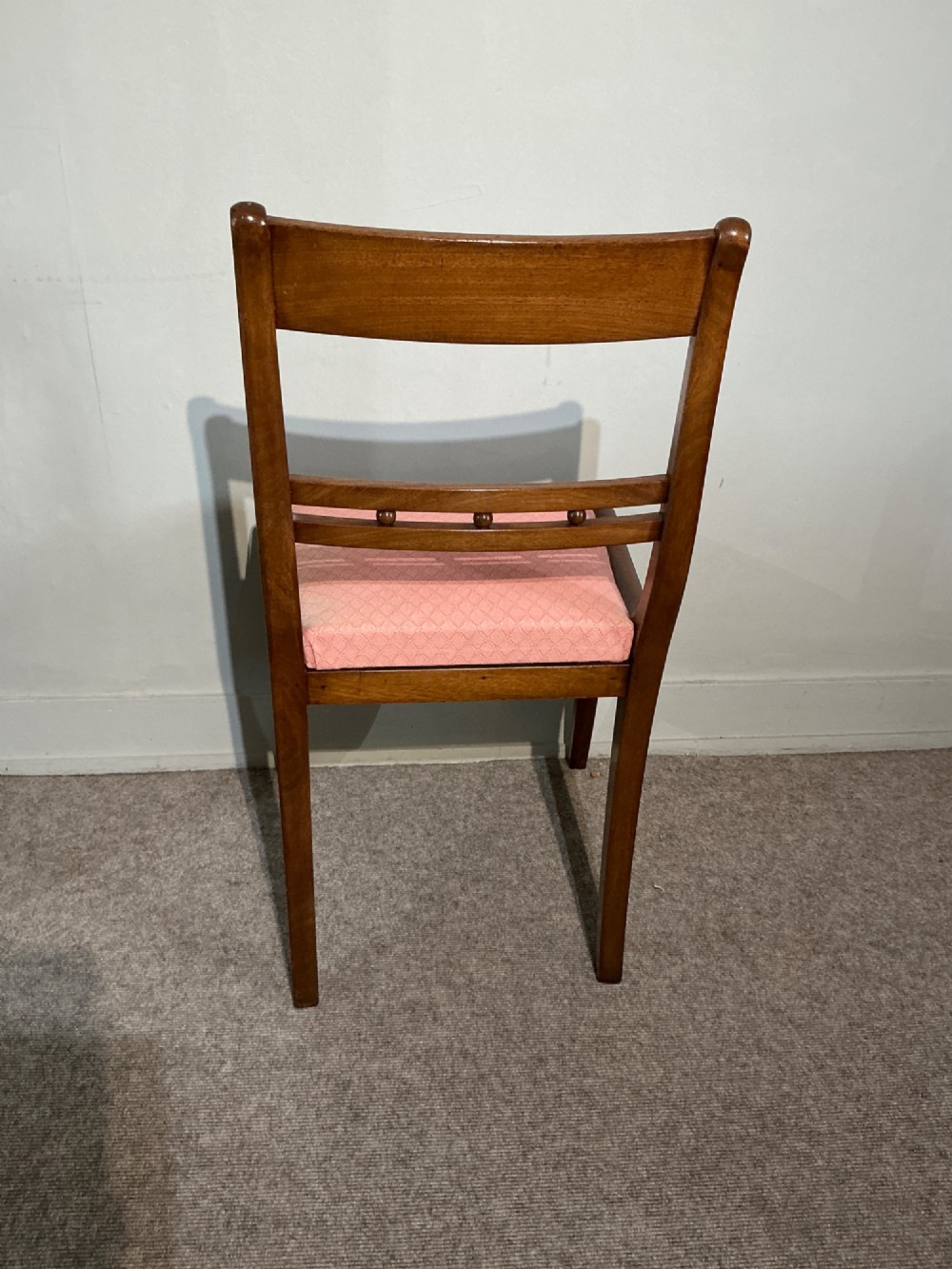 A set of six Regency mahogany dining chairs featuring tablet top rails, beaded crossbars, and rose-pink upholstered drop-in seats. View VI